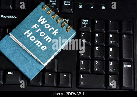Blue notebook with text written on top of black keyboard on the table. Working concept Stock Photo