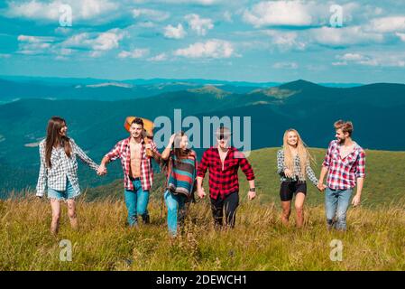 Groups of Friends Relaxing are Enjoying Outside Tents Camping. Group people in a hike through the mountains. Friends on a camping trip walking. Stock Photo