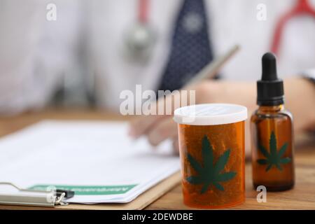 Doctor writes prescription for cannabis extract and leaves closeup Stock Photo
