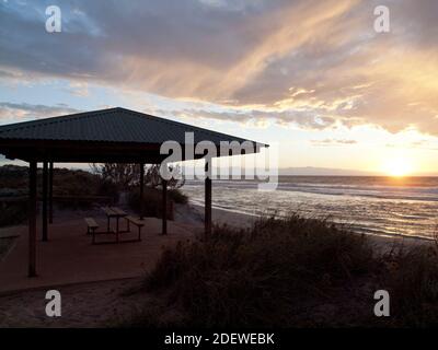 Indian Ocean sunset and empty beachside picnic shelter, Blue Holes, Kalbarri, Western Australia Stock Photo