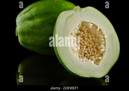 Green round papaya on a black background with reflection Stock Photo