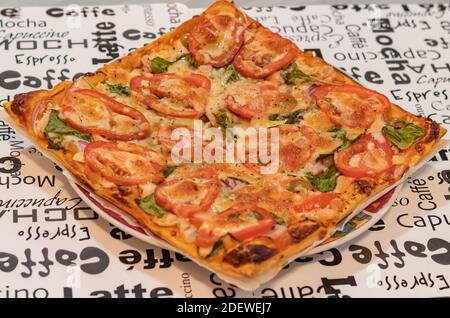 Delicious homemade square pizza with tomatos. Close up, selective focus, concept photo food. Stock Photo
