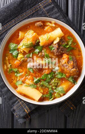 Haitian joumou beef and pumpkin soup closeup in the plate on the table. Vertical top view from above Stock Photo