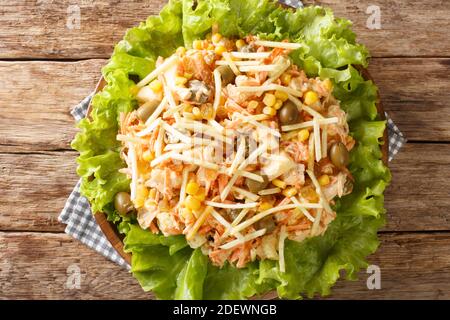 Delicious Brazilian Salpicao salad of chicken, vegetables, raisins seasoned with mayonnaise and topped potato sticks close-up in a plate on the table. Stock Photo