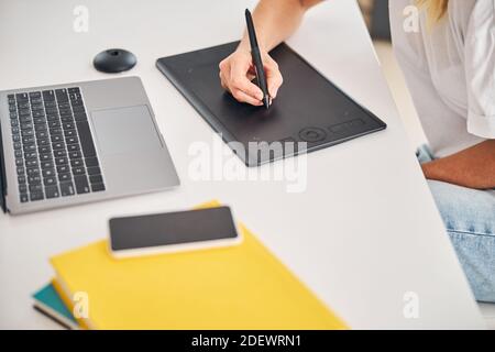 Female artist using a gadget for creating digital drawings Stock Photo