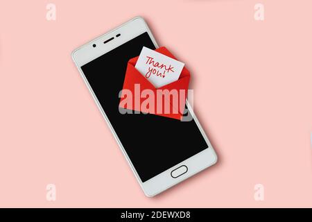 Red envelope and thank you letter with mobile phone on pink background Stock Photo