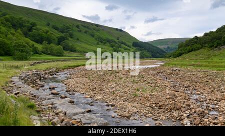 River Swale in scenic countryside valley (low shallow water channel in dry summer weather & riverbed rocks) - Swaledale, Yorkshire Dales, England, UK. Stock Photo