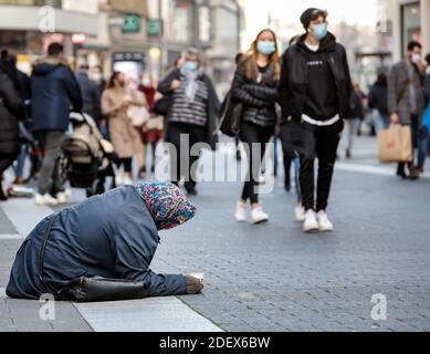 Duesseldorf, North Rhine-Westphalia, Germany - Beggar woman sits in the old part of Duesseldorf in times of the Corona crisis during the second part l Stock Photo