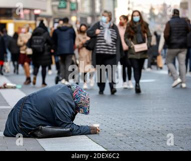 Duesseldorf, North Rhine-Westphalia, Germany - Beggar woman sits in the old part of Duesseldorf in times of the Corona crisis during the second part l Stock Photo