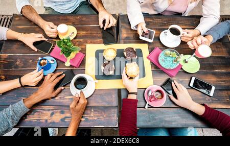Top angle view of hands with phones at coffee shop restaurant - People having breakfast together with mobile smartphones at fashion cafe bar Stock Photo