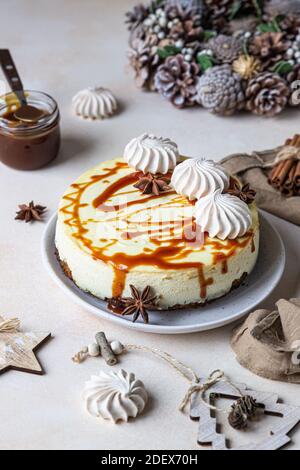 Vanilla cheesecake with carrot cake crust served with salty caramel topping and meringue, light concrete background. Selective focus. Stock Photo