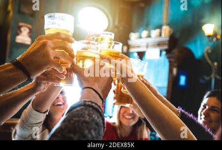 Group of happy friends drinking and toasting beer at brewery bar restaurant - Friendship concept with young people having fun together at vintage pub Stock Photo