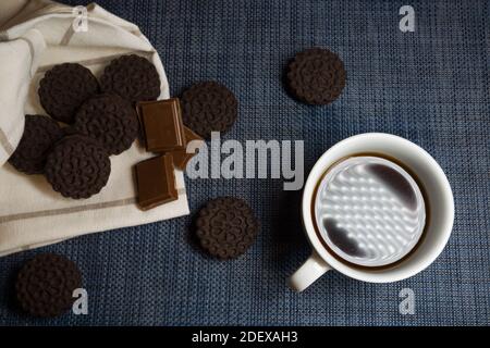 Dark brown cakes with chocolate cubes and a cup of coffee, top view Stock Photo