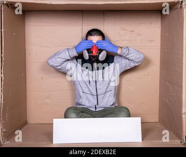 man in a protective mask covers his eyes with his hands Stock Photo