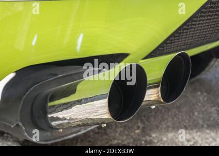 Close up of the chrome twin exhaust pipes on a lime green De Tomaso Pantera Stock Photo