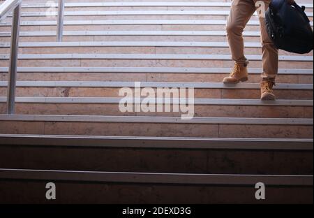 Unrecognizable man running into the underground with a backpack in his hands. Panoramic photography concept 2020. Everyday lifestyle. Stock Photo