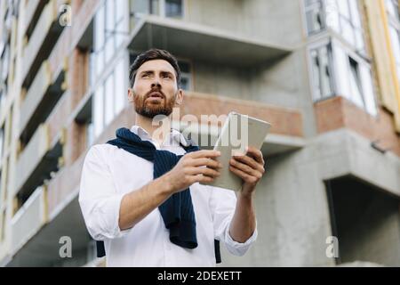 Focused architect using tablet at construction site Stock Photo