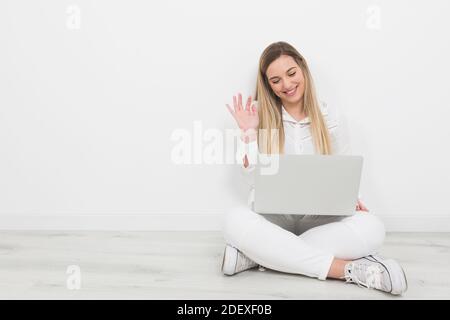 young woman greeting on video call with the computer on a white background Stock Photo