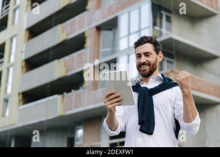 Bearded man controlling building process with digital tablet Stock Photo