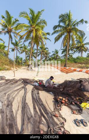 India, Goa, Colva beach, Fishermen mending nets Stock Photo