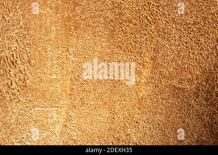 Crumpled golden aluminum foil background, abstract texture Stock Photo