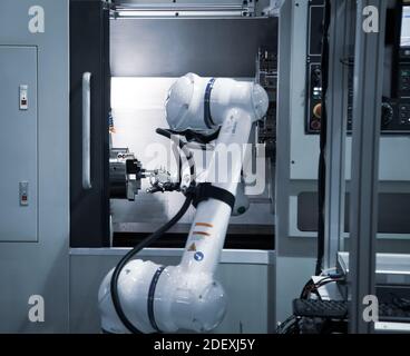 Automated CNC machine loading with robotic arm. Selective focus Stock ...