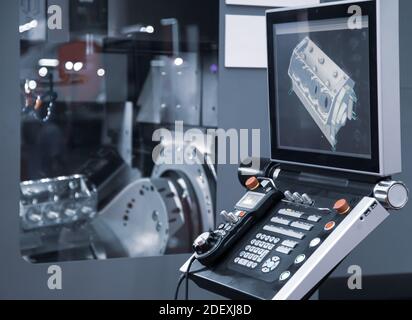 Control panel of 5-axis CNC milling machine cutting automotive engine part. Industrial manufacturing metalwork Stock Photo