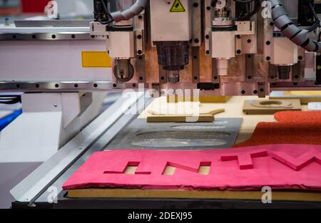 CNC laser cutting machine cutting car carpet mat and engine gasket. Industrial manufacturing Stock Photo