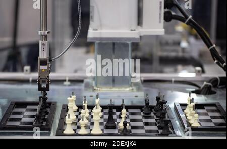 Industrial robot playing chess. Artificial Intelligence AI technology Stock Photo