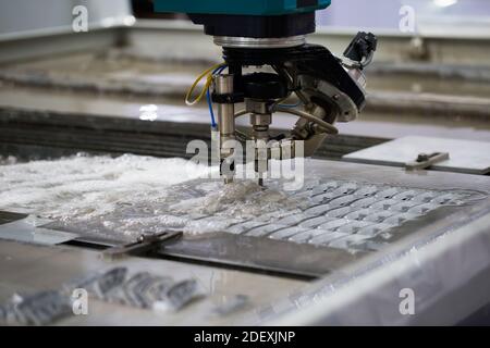 Modern CNC Abrasive water jet cutting machine using high pressure water jet to cut metal. Industrial metalworking machinery Stock Photo