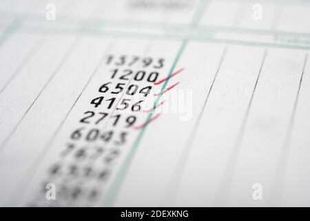 A factoring column of multiple digit numbers with some red check marks. Stock Photo