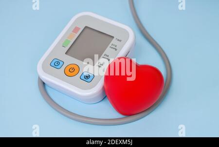 Electronic tonometer for measure blood pressure with red heart closeup Stock Photo