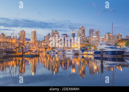 Vancouver city skyline shortly after sunset with boats docked in the harbour. Stock Photo