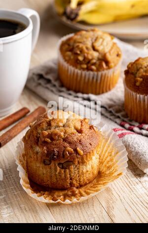 Banana nut muffin with bananas and muffins in background on a rustic wooden table Stock Photo