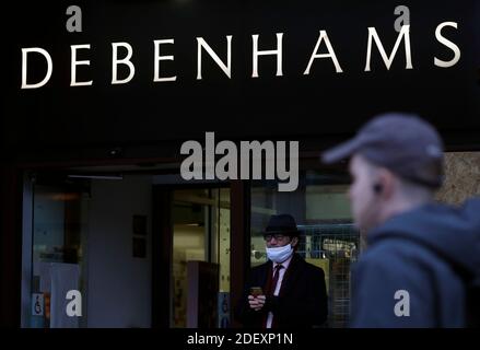 Nottingham, Nottinghamshire, UK. 2nd December 2020. A man stands outside a Debenhams store after the department store chain collapsed but opened its stores for a stock clearance sale. Credit Darren Staples/Alamy Live News. Stock Photo