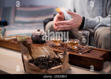 Close-up of the chinese tea ceremony ritual. Hands pour hot water into special vessels on a bamboo board Stock Photo