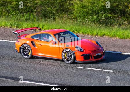 2016 orange Porsche 911 GT3 RS sports car ; Vehicular traffic, moving vehicles, cars, vehicle driving on UK roads, motors, motoring on the M6 motorway highway UK road network. Stock Photo