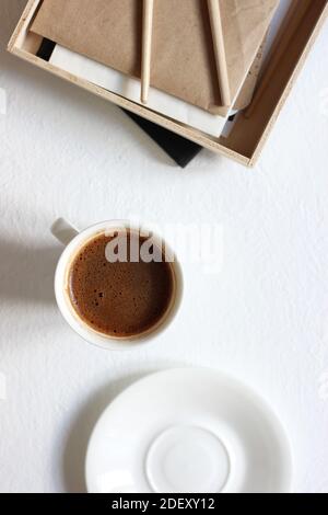 Top View of Composition with Black Coffee, Wooden Box with Kraft Paper and Painting Brushes. Stock Photo