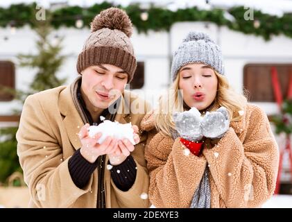 First Snowfall. Young Romantic Couple Playing With Snow, Enjoying Winter Day Outdoors Stock Photo