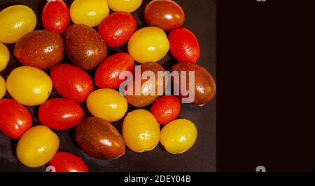 Cherry Tomatoes. Copy Space. Colorful washed and ready to eat cherry tomatoes. isolated on dark background. Room to write. Stock Image. Stock Photo