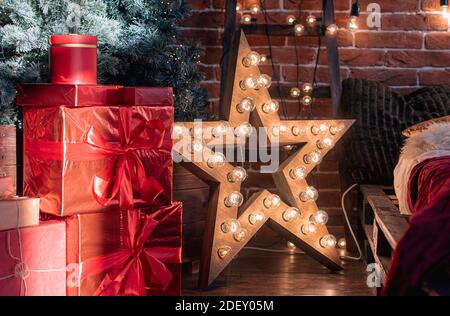 Christmas or New Year interior of living room, apartment with Christmas tree, gift boxes, gloving star, garlands Stock Photo