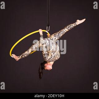 Aerial acrobat in the ring. A young girl performs the acrobatic ...