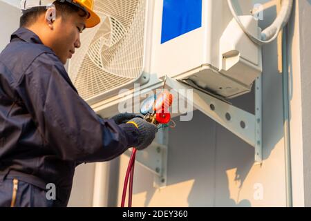 Asian technician is checking air conditioner, After-sales service concept Stock Photo