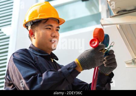 Technician vacuum pump evacuates and checking air conditioner, After-sales service concept Stock Photo