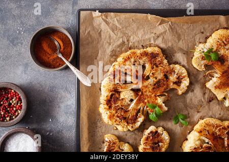 cauliflower steaks with herb and spice on baking tray. plant based meat substitute Stock Photo