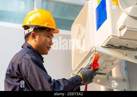 Technician vacuum pump evacuates and checking air conditioner, After-sales service concept Stock Photo