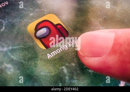 Tambov, Russian Federation - November 17, 2020 Person finger ready to start Among Us application on iPad. Stock Photo