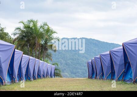 Many blue tents lined up on the lawn background Mountains and sky. Stock Photo