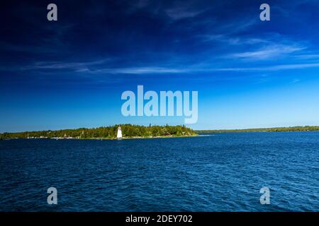 View of the lighthouse and land in the vast expanse of Lake Huron, ON. Spectacular scenery in the summer in Georgian Bay in ON, Canada. There are over Stock Photo