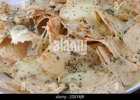 triangle nachos with hot cheese sauce as snack mexican food Stock Photo